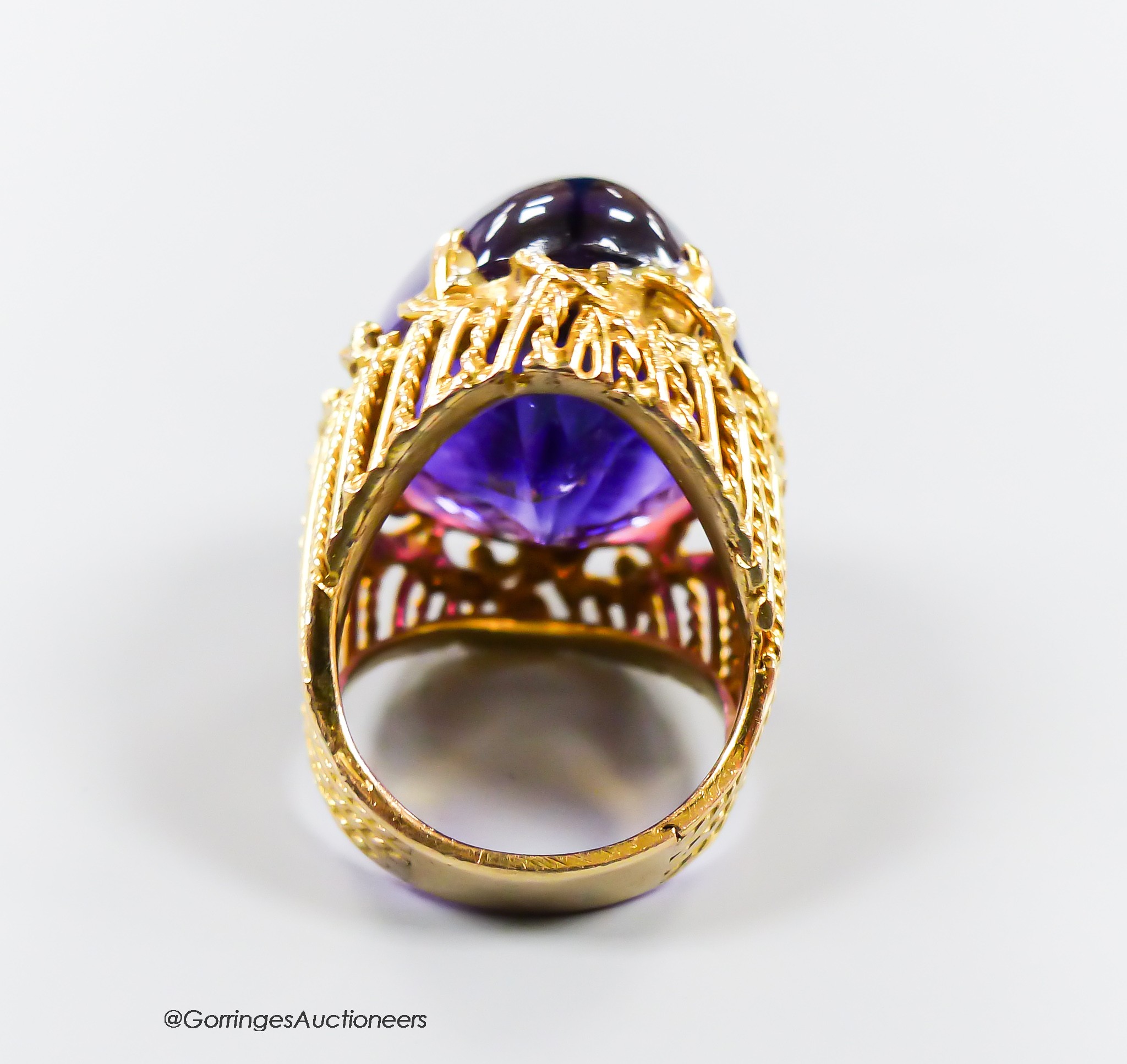 A pierced 585 yellow metal and large cabochon amethyst set dress ring, size K/L, gross 17.4 grams.